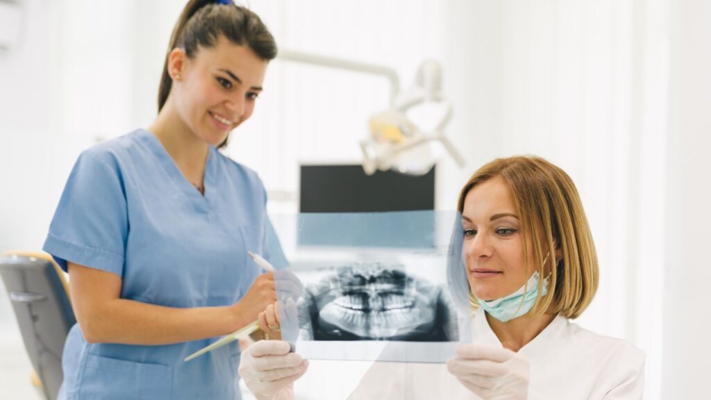 Dentist explaining x-ray to assistant